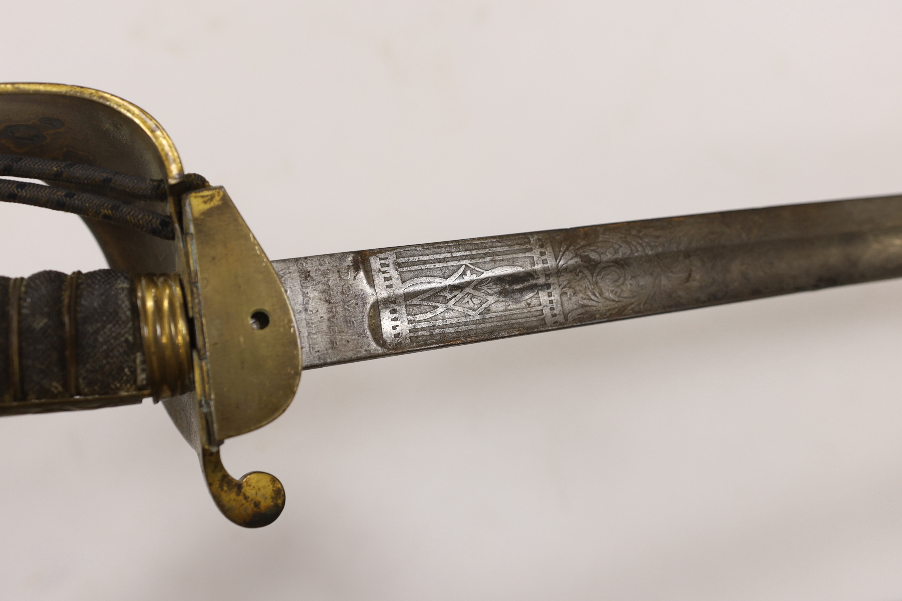 A late Victorian naval officer’s sword with regulation brass hilt, lion head pommel and blade etched with crown, VR and fouled anchor in its leather scabbard, top mount missing, blade 77cm